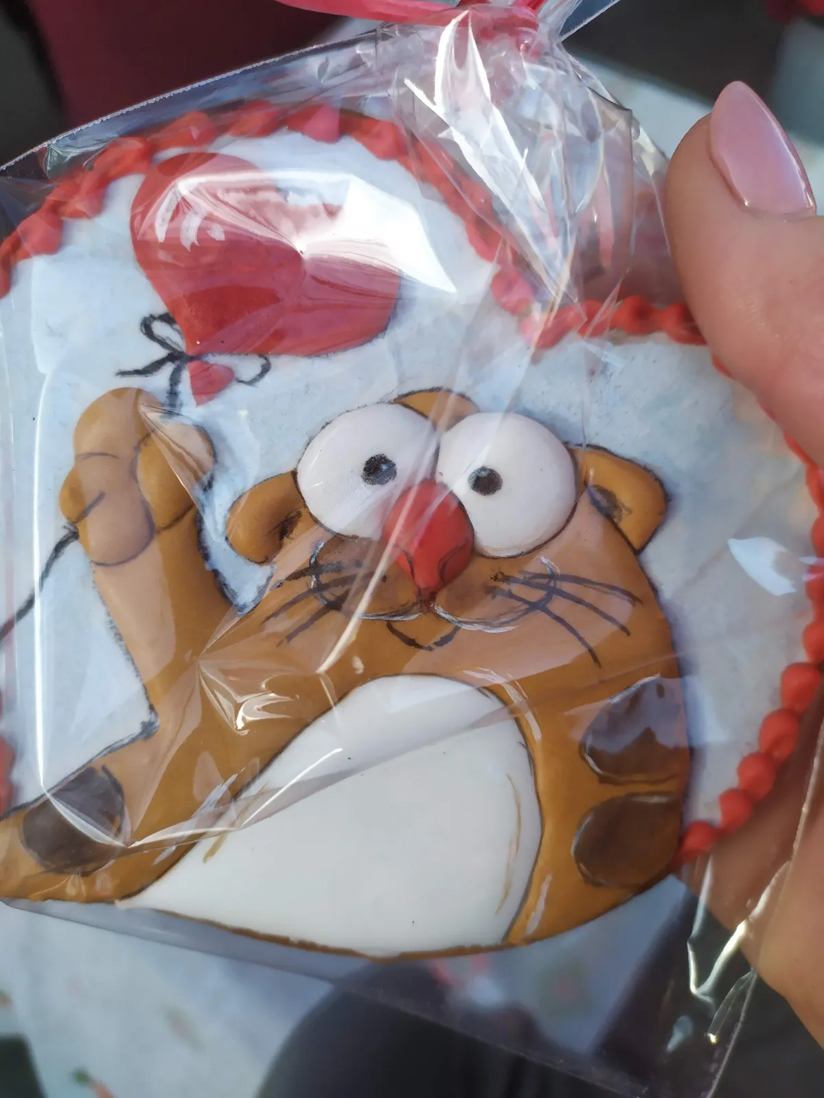 Hand-painted cat holding heart balloon cookie